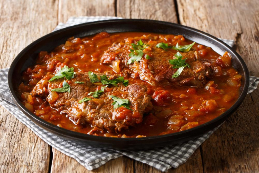 &lt;p&gt;smothered beef steak cooked in tomato sauce with vegetables close-up on the table. Horizontal&lt;/p&gt;