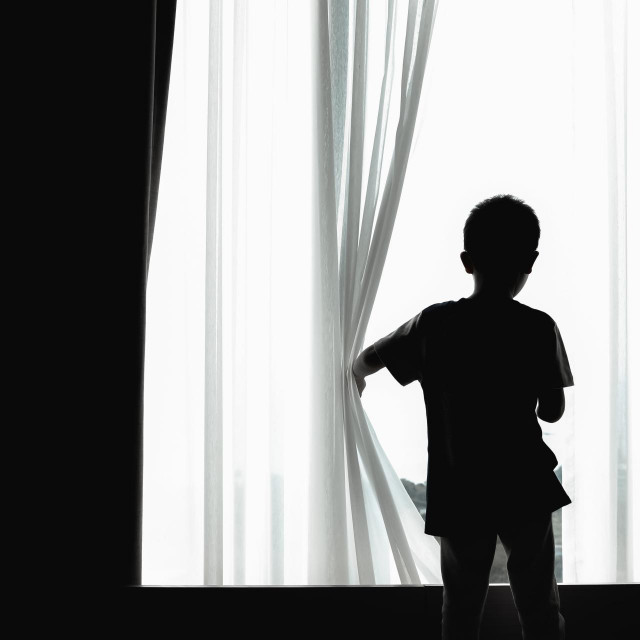 &lt;p&gt;child feeling bored due to staying at home and restricted from coronavirus pandemic. school closing has a negative impact on children‘s mental health. silhouette of a kid opening curtain window.&lt;/p&gt;