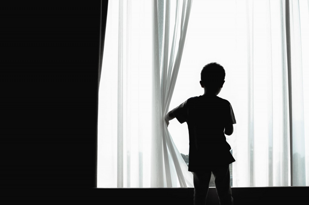 &lt;p&gt;child feeling bored due to staying at home and restricted from coronavirus pandemic. school closing has a negative impact on children‘s mental health. silhouette of a kid opening curtain window.&lt;/p&gt;