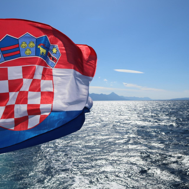 &lt;p&gt;Flag of Croatia over the sea against the backdrop of the sea coast, mountains on the horizon, blue sunny sky&lt;/p&gt;