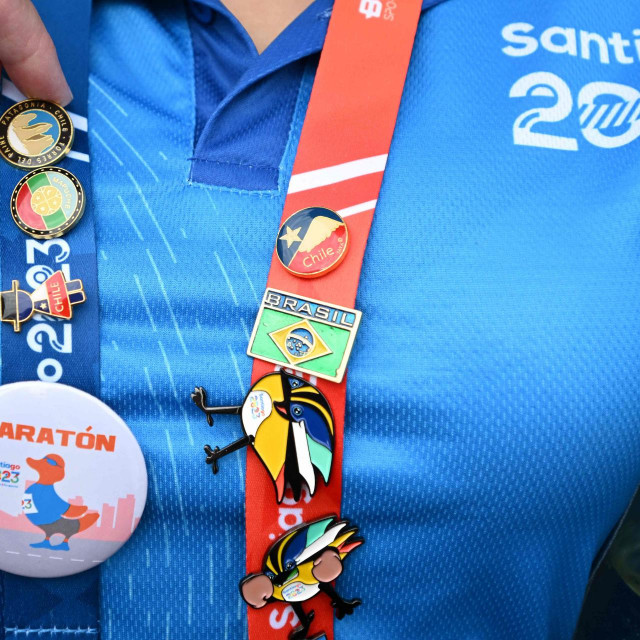 &lt;p&gt;A woman wears pins of different sport events during the Pan American Games Santiago 2023 in Santiago on October 25, 2023. (Photo by Raul ARBOLEDA/AFP)&lt;/p&gt;
