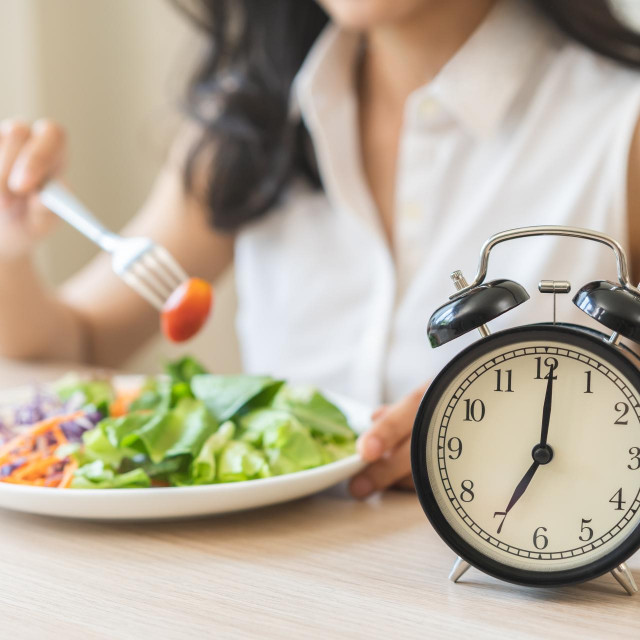 &lt;p&gt;Intermittent fasting with clock, health asian young woman, girl weight loss, eating green fresh vegetable salad on dish, plate with eat healthy of breakfast food in morning, lunch on a table at home.&lt;/p&gt;