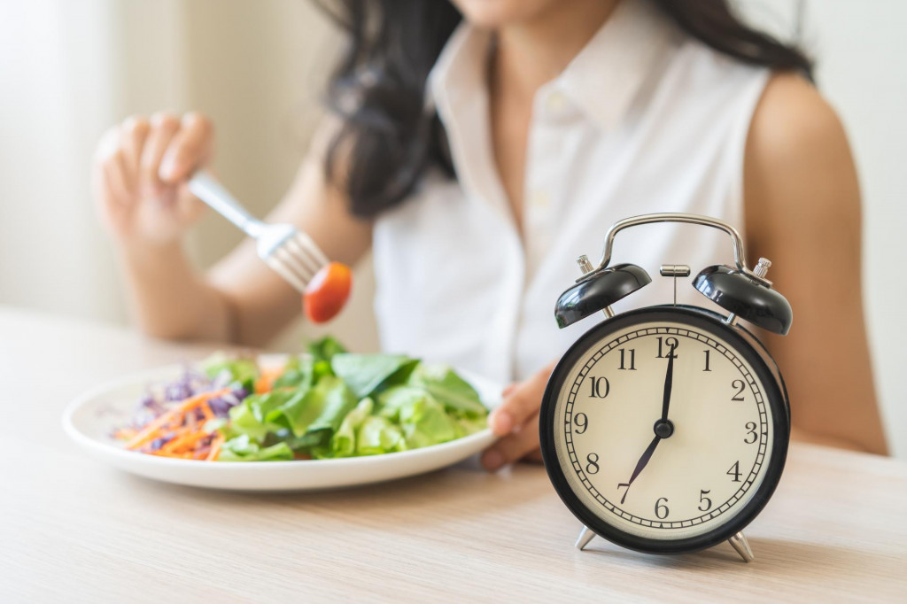 &lt;p&gt;Intermittent fasting with clock, health asian young woman, girl weight loss, eating green fresh vegetable salad on dish, plate with eat healthy of breakfast food in morning, lunch on a table at home.&lt;/p&gt;