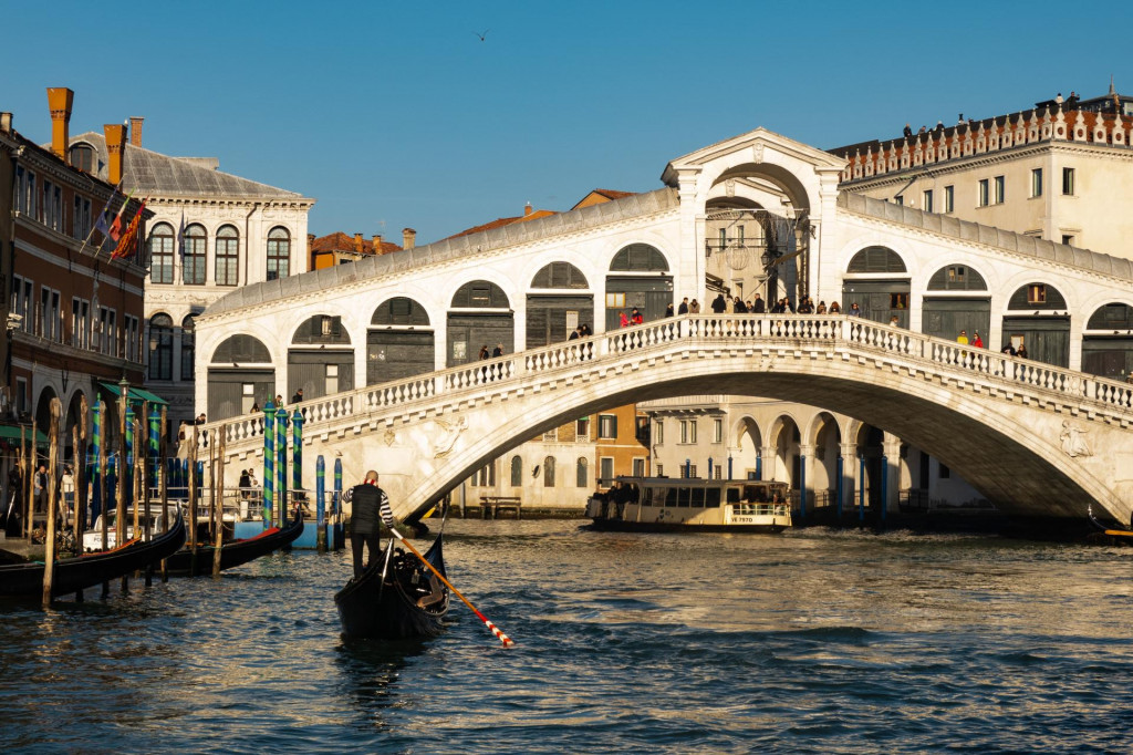 &lt;p&gt;A typical gondola boat next to Rialto bridge is seen in Venice, Italy, on January 30th, 2024. Gondolas are traditional, flat-bottomed rowing boats that are iconic to the city of Venice. These slender, handcrafted boats are typically operated by a gondolier who skillfully navigates through the intricate network of canals in Venice. Gondolas are known for their elegant and distinctive design, featuring a curved prow, ornate decorations, and a flat hull. Rialto Bridge in Venice is one of the iconic landmarks in the city. The bridge, with its distinctive architecture featuring a central portico and shops along its length, is a popular destination for tourists and locals alike. (Photo by Lorenzo Di Cola/NurPhoto) (Photo by Lorenzo Di Cola/NurPhoto/NurPhoto via AFP)&lt;/p&gt;