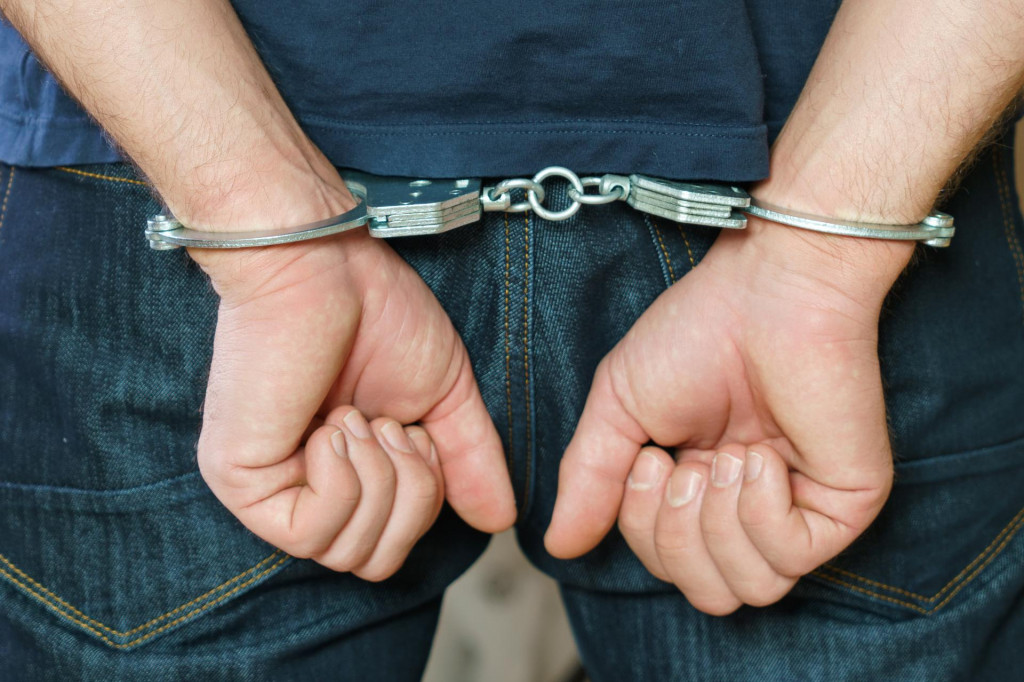 &lt;p&gt;Arrested man handcuffed hands at the back.&lt;/p&gt;