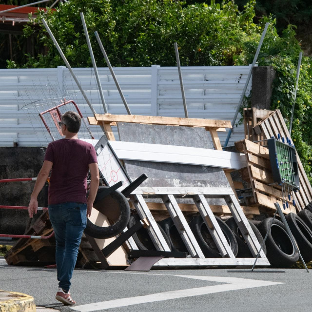 &lt;p&gt;A man walks past a roadblock barricade, set up by residents, in the Motor Pool district in Noumea on May 16, 2024, amid protests linked to a debate on a constitutional bill aimed at enlarging the electorate for upcoming elections of the overseas French territory of New Caledonia. France deployed troops to New Caledonia‘s ports and international airport, banned TikTok and imposed a state of emergency on May 16 after three nights of clashes that have left four dead and hundreds wounded. (Photo by Delphine Mayeur/AFP)&lt;/p&gt;