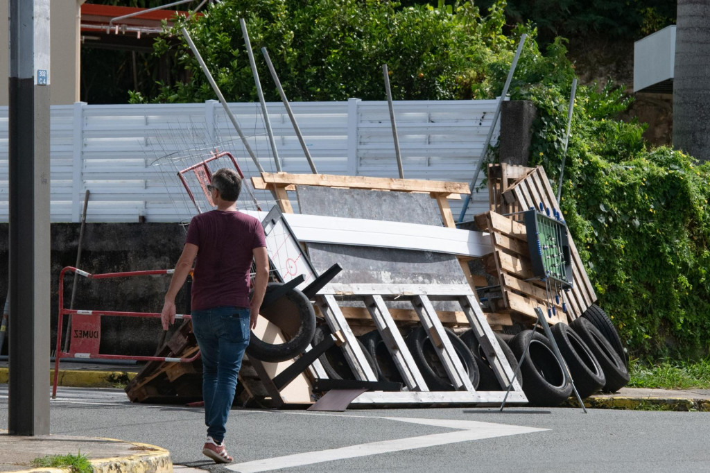 &lt;p&gt;A man walks past a roadblock barricade, set up by residents, in the Motor Pool district in Noumea on May 16, 2024, amid protests linked to a debate on a constitutional bill aimed at enlarging the electorate for upcoming elections of the overseas French territory of New Caledonia. France deployed troops to New Caledonia‘s ports and international airport, banned TikTok and imposed a state of emergency on May 16 after three nights of clashes that have left four dead and hundreds wounded. (Photo by Delphine Mayeur/AFP)&lt;/p&gt;