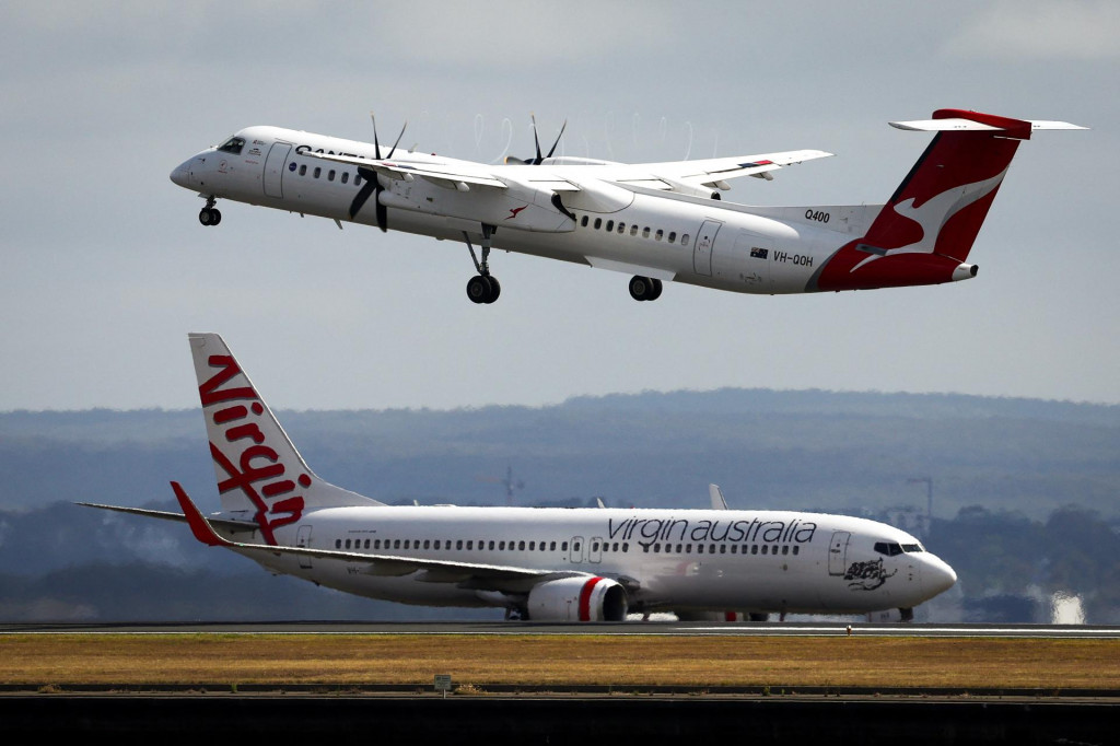 &lt;p&gt;A Virgin Airways plane travels down the runway as a QantasLink Dash 8-400 series plane takes off at Sydney‘s Kingsford Smith international airport on November 3, 2023. (Photo by DAVID GRAY/AFP)&lt;/p&gt;