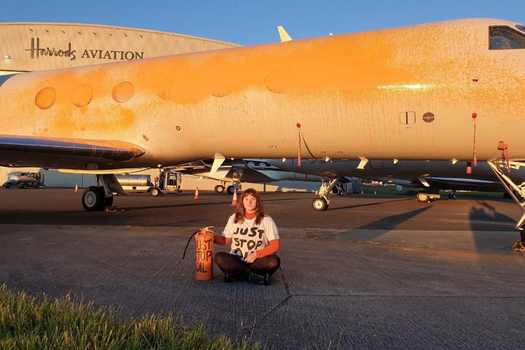&lt;p&gt;Aktivistica Just Stop Oil sjedi ispred zrakoplova obojanog narančastim sprejem u zračnoj luci Stansted Airport nedaleko Londona&lt;/p&gt;