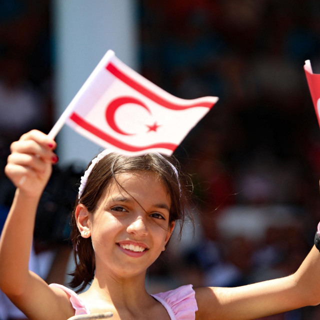 &lt;p&gt;Mlada djevojka maše zastavama Turske i Sjevernog Cipra dok Cipar obilježava 50. godišnjicu turske invazije&lt;/p&gt;