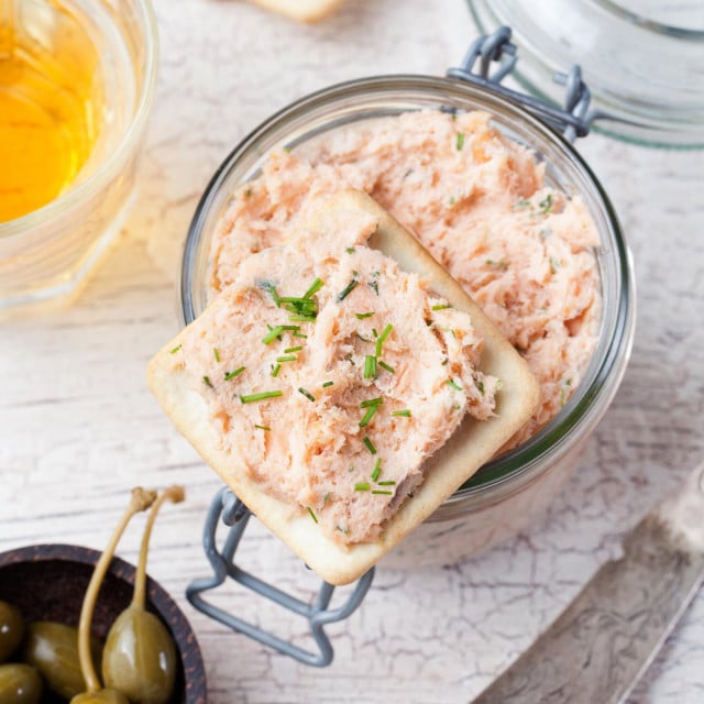 &lt;p&gt;Smoked salmon and soft cheese spread, mousse, pate in a jar with crackers, olives and capers on a wooden background Top view&lt;/p&gt;