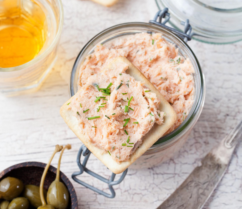 &lt;p&gt;Smoked salmon and soft cheese spread, mousse, pate in a jar with crackers, olives and capers on a wooden background Top view&lt;/p&gt;