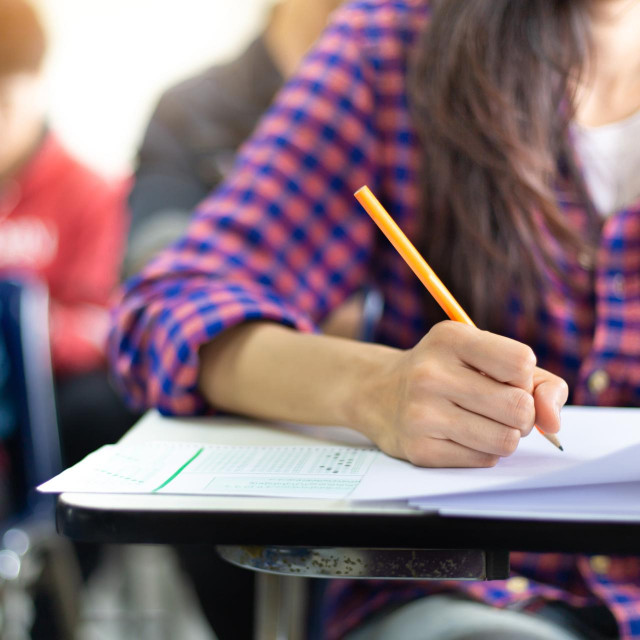 &lt;p&gt;high school,university student study.hands holding pencil writing paper answer sheet.sitting lecture chair taking final exam attending in examination classroom.concept scholarship for education abroad&lt;/p&gt;