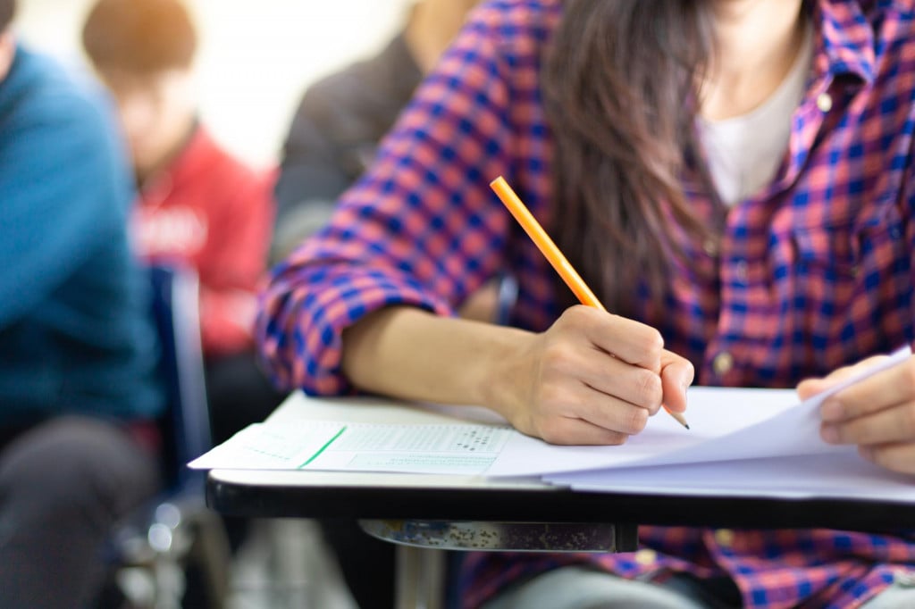 &lt;p&gt;high school,university student study.hands holding pencil writing paper answer sheet.sitting lecture chair taking final exam attending in examination classroom.concept scholarship for education abroad&lt;/p&gt;