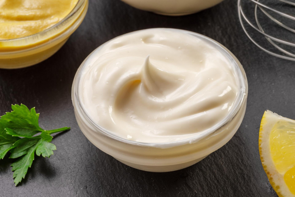 &lt;p&gt;Glass bowl of homemade mayonnaise on black stone slate serving plate close-up.&lt;/p&gt;