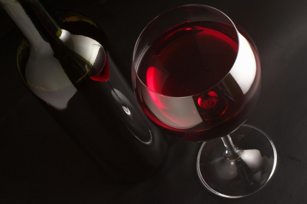 &lt;p&gt;Glass of red wine and bottle on black background.&lt;/p&gt;