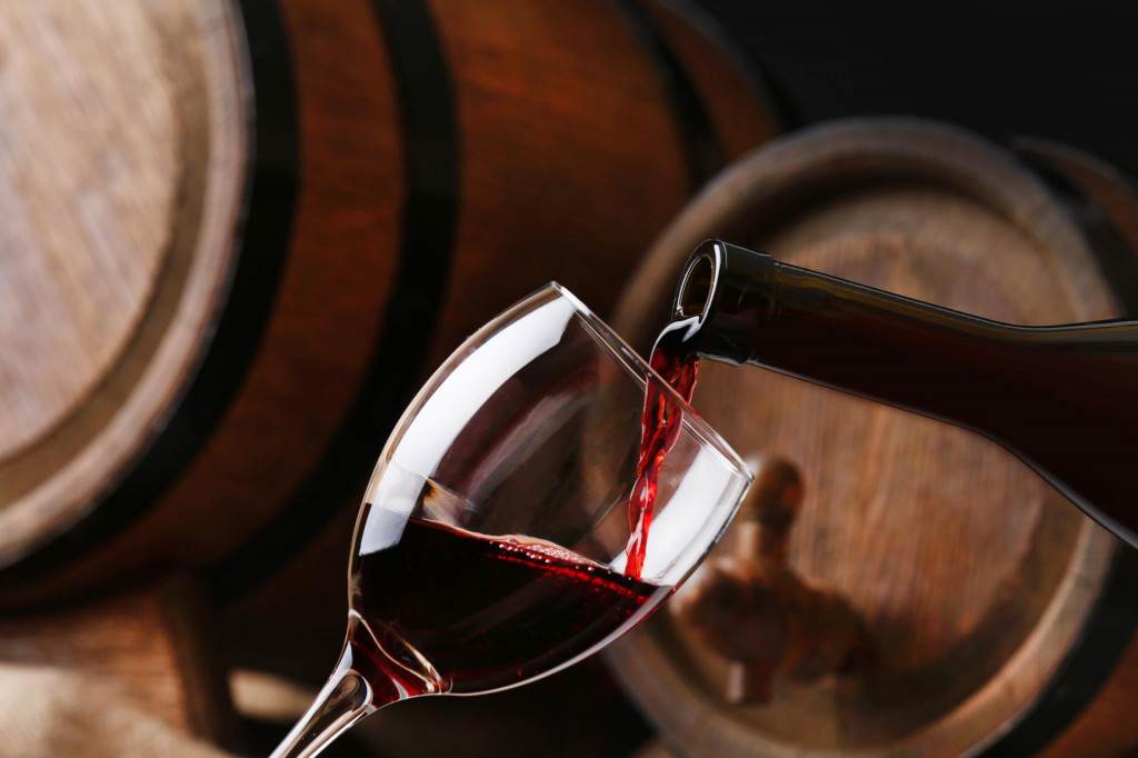 &lt;p&gt;Pouring red wine from bottle into glass with wooden wine casks on background&lt;/p&gt;