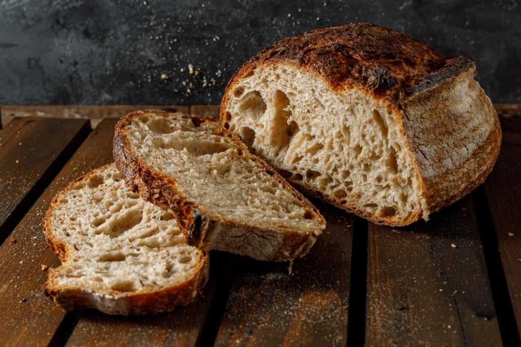 &lt;p&gt;Freshly baked sourdough bread is beautifully sliced and artfully displayed on a charming rustic wooden surface&lt;/p&gt;