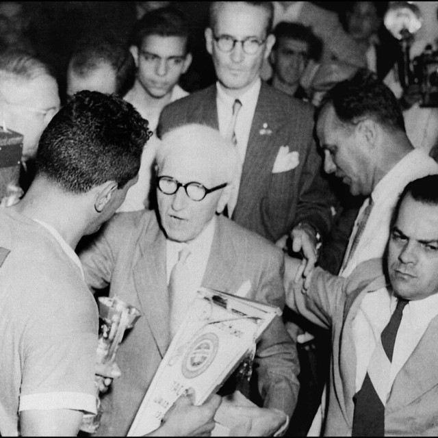 <p>Predsjednik FIFA-e Jules Rimet uručuje trofej urugvajskim nogometa&scaron;ima</p>