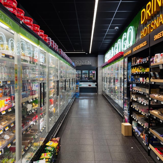 <p>Manchester, UK - September 25, 2025Vibrant SPAR grocery store aisle featuring cold drinks, snacks, and illuminated glass coolers in a busy setting.</p>