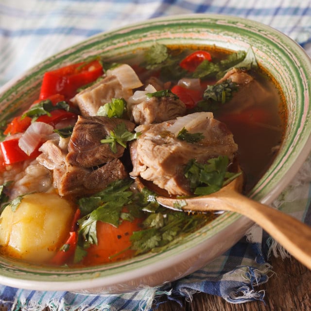 <p>Shurpa lamb soup with vegetables closeup at the plate on the table. horizontal</p>