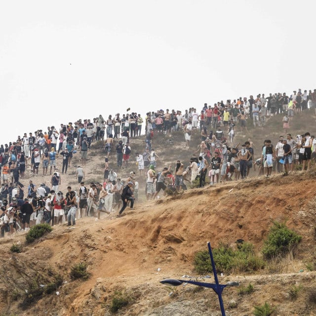<p>Migranti koji poku&scaron;avaju prijeći u &scaron;panjolsku sjevernoafričku enklavu Ceutu okupljaju se na vrhu brda tijekom sukoba s marokanskim sigurnosnim snagama u blizini grada Fnideqa, na granici između Maroka i &Scaron;panjolske, 31. srpnja 2026.</p>

<p>Europska unija je 31. srpnja poku&scaron;avala obuzdati jednu od najvećih migrantskih kriza s kojima se blok suočio posljednjih godina, nakon &scaron;to su se deseci tisuća ljudi u samo nekoliko dana slili u &scaron;panjolsku sjevernoafričku enklavu Ceutu.</p>