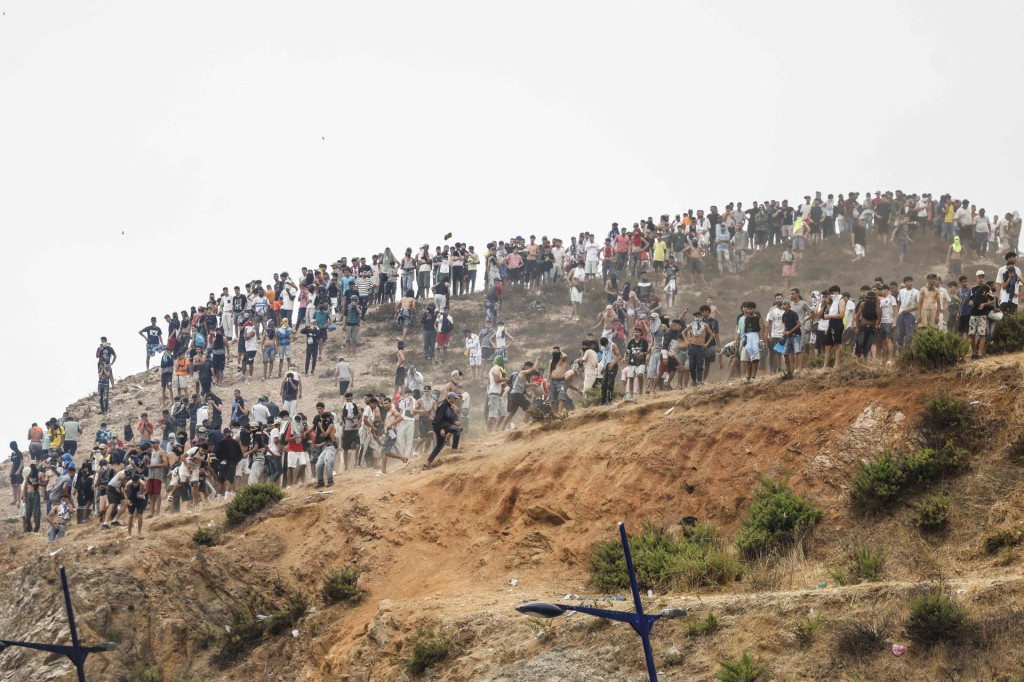 <p>Migranti koji poku&scaron;avaju prijeći u &scaron;panjolsku sjevernoafričku enklavu Ceutu okupljaju se na vrhu brda tijekom sukoba s marokanskim sigurnosnim snagama u blizini grada Fnideqa, na granici između Maroka i &Scaron;panjolske, 31. srpnja 2026.</p>

<p>Europska unija je 31. srpnja poku&scaron;avala obuzdati jednu od najvećih migrantskih kriza s kojima se blok suočio posljednjih godina, nakon &scaron;to su se deseci tisuća ljudi u samo nekoliko dana slili u &scaron;panjolsku sjevernoafričku enklavu Ceutu.</p>