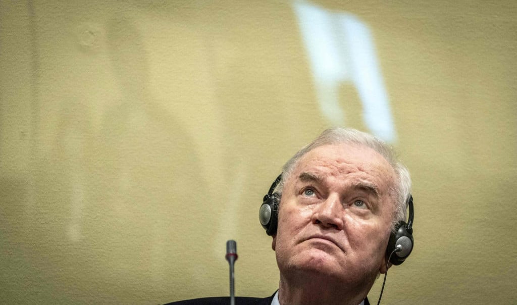 <p>(FILES) Ex-Bosnian Serb military chief Ratko Mladic sits in the defendant box prior to the hearing of the final verdict on appeal against his genocide conviction over the 1995 Srebrenica massacre, Europe&lsquo;s worst act of bloodshed since World War II, on June 8, 2021 at the International Residual Mechanism for Criminal Tribunals (IRMCT) in The Hague. Former Bosnian military Serb leader and war criminal Ratko Mladic has died in a prison hopsital in the Hague, according to Serbian state broadcaster RTS on August 27, 2026, after suffering several strokes. Mladic, 84, was dubbed the &rdquo;Butcher of Bosnia&rdquo; for his role in the 1995 Srebrenica massacre during the Bosnian war. (Photo by Jerry Lampen/ANP/AFP)/Netherlands OUT</p>