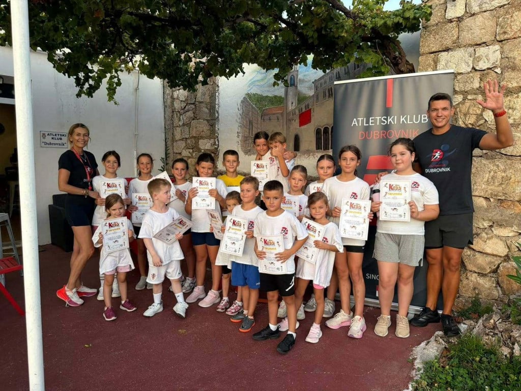<p>Mali sudionici Ljetne &scaron;kole atletike s trenerima Anom Perović Alamat i Vedadom Đugumom</p>