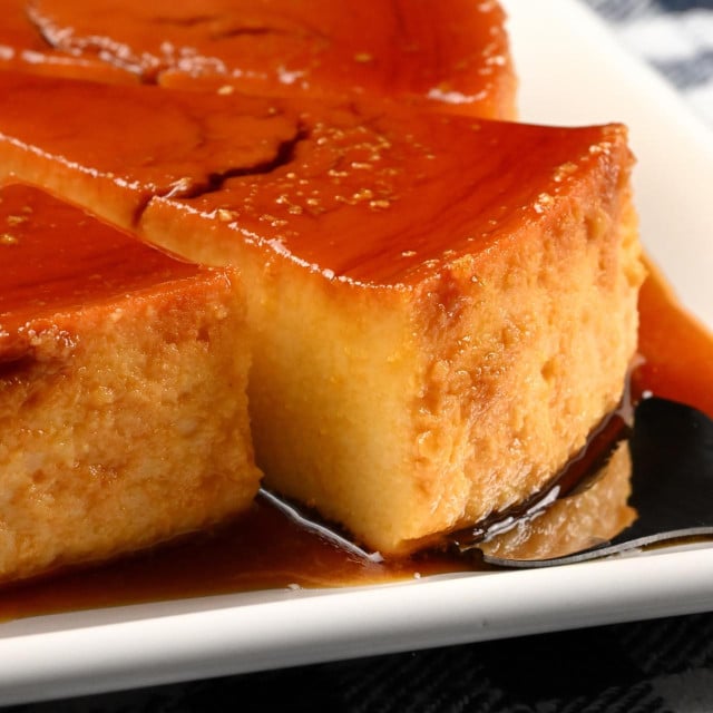 <p>Close-up of a slice of caramel flan served on a white plate</p>